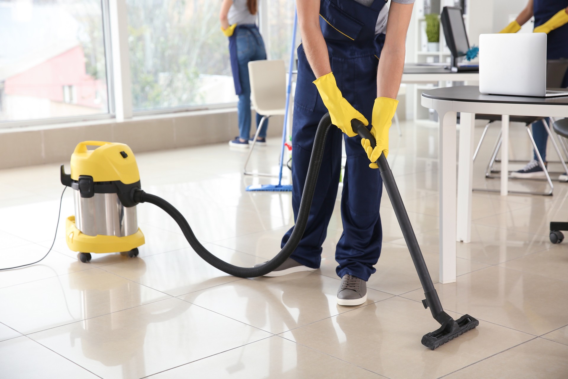 Janitor hoovering floor in office